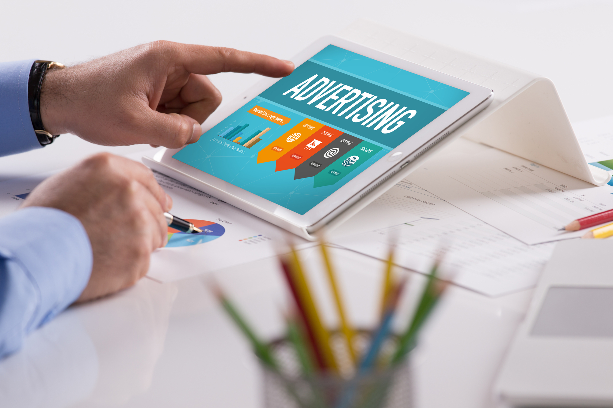 Businessman working on tablet with ADVERTISING on a screen