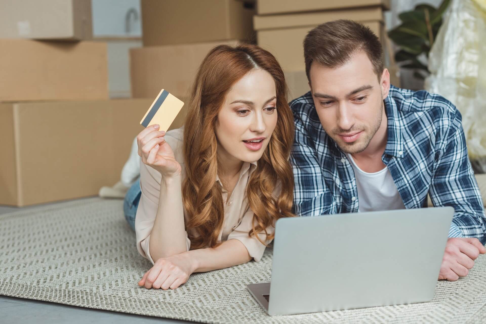 Couple buying goods online together at a new home, moving house concept