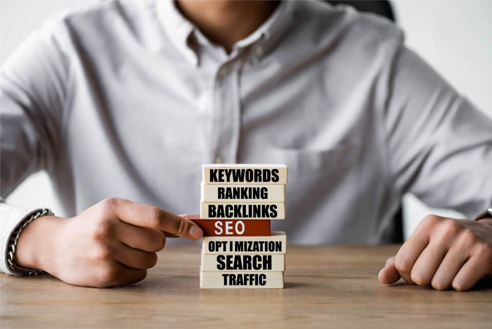 Businessman standing in front of a chalkboard with web design terms written on it