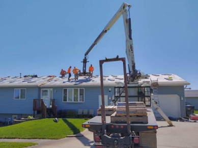 Good lighting and angle capture the team and equipment working safely on a residential job site